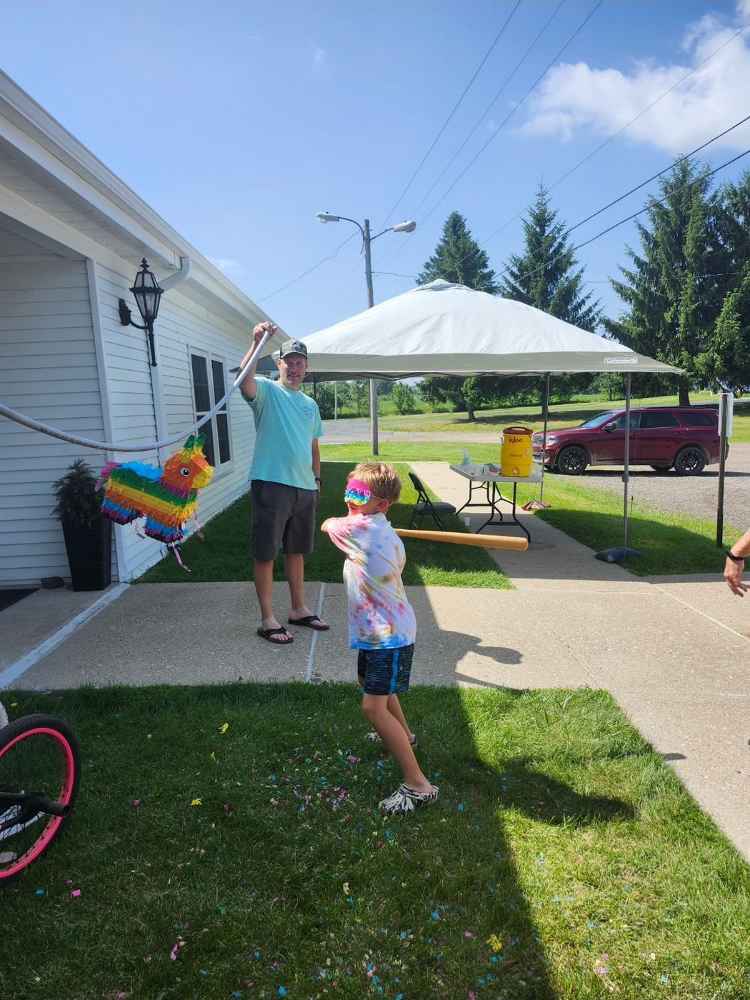 A child swinging at the VBS pinata outside