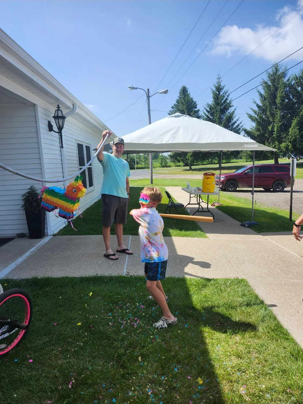 A child swinging at the VBS pinata outside