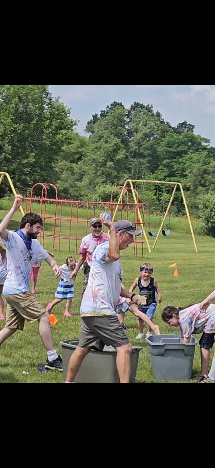 Kids and leaders playing water games outside during VBS